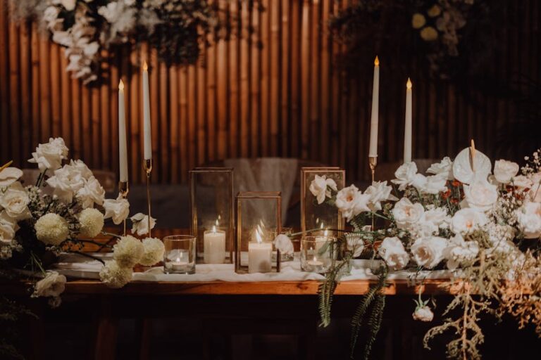 A sophisticated wedding table setup featuring candlelight and white floral arrangements, creating a romantic ambiance.