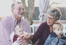 Grandparents spending joyful moments with their grandchildren in an outdoor setting, captured candidly.