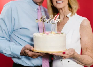 Ideias para celebrar o aniversário de namoro An elderly couple joyfully holding a 'Mr & Mrs' wedding anniversary cake.