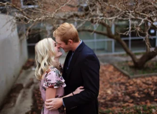 Planos românticos para o outono: 10 ideias incríveis A young couple sharing a romantic moment amidst autumn leaves, capturing love and joy outdoors.